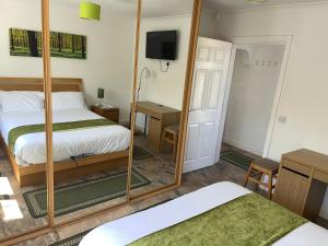 a bedroom with two beds and a mirror at Blackthorn Meadow in Pontypool