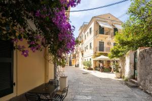 an empty street in an old town with purple flowers at Casa Petridou 2 in Corfu