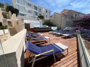 a deck with blue lounge chairs on top of a building at Belado Residence Bol in Bol