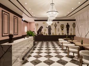 ein Restaurant mit kariertem Boden und Tischen und Stühlen in der Unterkunft Mural Piraeus Hotel in Piräus