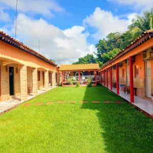 a yard between two buildings with green grass at Pousada Açaí in Salvaterra