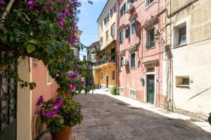 an alley in an old town with flowers at Casa Petridou 2 in Corfu +3 photos