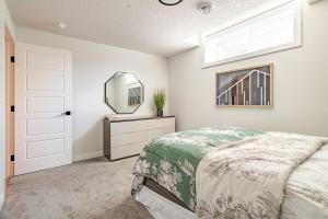 a bedroom with a bed and a mirror at Hotchlair Private Suite with Kitchen, Dining & Cozy Living Area in Calgary
