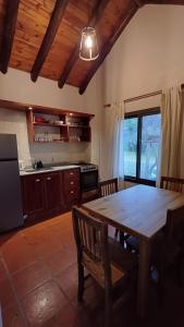 a kitchen with a wooden table and a dining room at Casa Tala in Villa Las Rosas