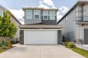a house with a white garage door at Hotchlair Private Suite with Kitchen, Dining & Cozy Living Area in Calgary