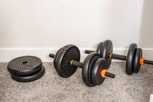 two black dumbbells sitting next to a wall at Hotchlair Private Suite with Kitchen, Dining & Cozy Living Area in Calgary