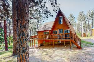 a house with a large deck in the woods at Mountain Escape in Sturgis