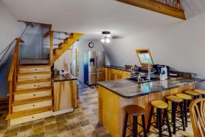 a kitchen with a counter and some wooden stools at Mountain Escape in Sturgis