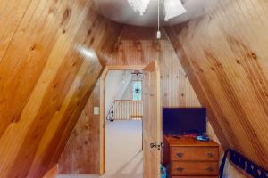 an attic room with wooden floors and a room with a dresser at Mountain Escape in Sturgis
