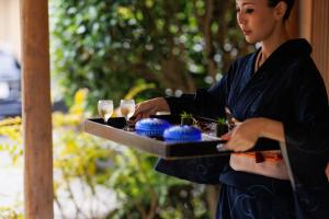a woman holding a tray with glasses of champagne at Kotonoyado Musashino in Nara +121 photos