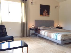 a bedroom with a bed and a chair at La Grande Bouisse gites avec piscine dans le Luberon, Provence in Céreste +80 photos