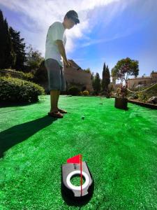 a man standing on a green lawn with a toilet at El Clos 3 in Conesa