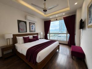 a bedroom with a large bed and a large window at ELYSIUM TOWER Luxury Hotel Apartments Facing Centaurus Mall Islamabad in Islamabad