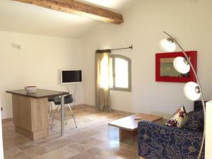 a living room with a table and a couch and a desk at La Grande Bouisse gites avec piscine dans le Luberon, Provence in Céreste