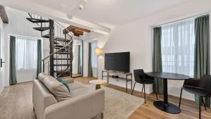 a living room with a couch and a spiral staircase at GLANDON Rooms Haldenhof - Self-Check-In in Lucerne