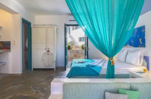 a bedroom with a bed with a blue curtain at Nefeli Hotel Leros in Agia Marina