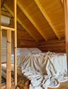 a bed in a room with a wooden ceiling at OHANA Cottages in Merisi in Merisi