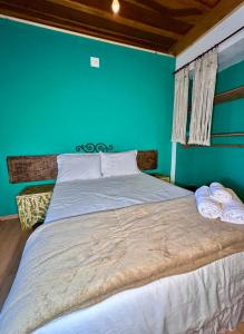 a bedroom with a large bed with a blue wall at Solar Maria Gomes - Lavras Novas MG in Lavras Novas