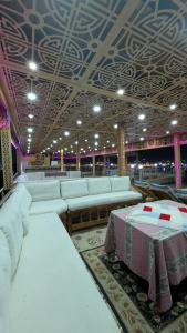 a large room with white couches and a table in it at Nagar Villa Apartments in Luxor