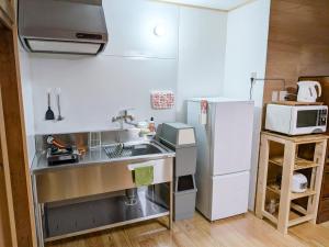 a small kitchen with a sink and a refrigerator at おかえりヒュッテ in Komagane
