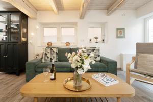 a living room with a green couch and a table at Haus 1805 Fehmarn in Fehmarn +51 photos