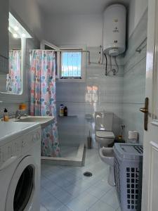 a bathroom with a washing machine and a toilet at House by the sea! in Platamonas +14 photos