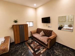 a living room with a couch and a television at The Third Space Varanasi in Rāmnagar