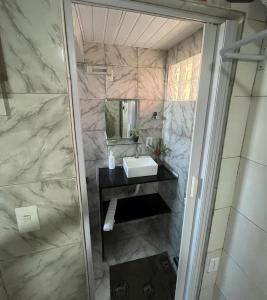 a bathroom with a sink and a mirror at Pousada do Benzinho in Cabedelo