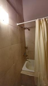 a bathroom with a shower curtain and a bath tub at Casa Tala in Villa Las Rosas