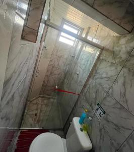 a bathroom with a shower and a toilet at Pousada do Benzinho in Cabedelo