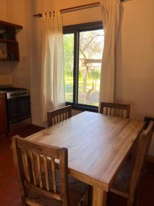 a wooden table in a kitchen with a large window at Casa Tala in Villa Las Rosas