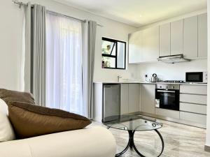 a living room with a couch and a glass table at Number 12, Jadde apartments in Sandton