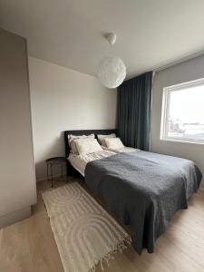a bedroom with a large bed and a window at Mistar Home in Gardur