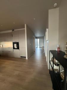 a large kitchen with white cabinets and a wooden floor at Mistar Home in Gardur
