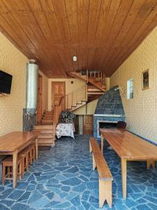 a room with wooden tables and a staircase in a house at Napertskala Guesthouse in Utsera