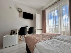 a bedroom with a bed and a desk and a television at Perełka Bałtyku in Władysławowo
