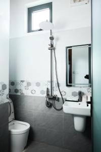 a bathroom with a sink and a toilet and a mirror at Phố Núi 2 Hotel in Pleiku +18 photos