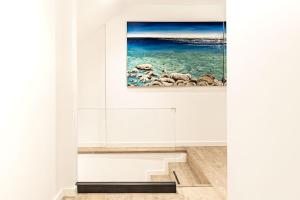 a staircase in a white room with a painting on the wall at Art Studios Gialova Navarino in Gialova +37 photos