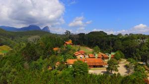 um grupo de casas numa colina com árvores em Pousada Vale Du'Carmo em Pedra Azul