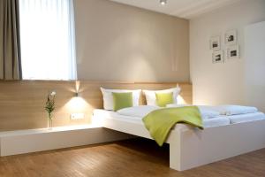 a bedroom with a large white bed with green pillows at Volkspark in Bamberg