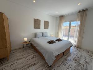 a white bedroom with a large bed and a window at La maison da serra in Quinta do Anjo +24 photos