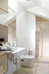 a white bathroom with a toilet and a sink at Volkspark in Bamberg