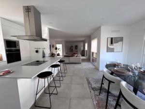 a kitchen and living room with a counter and stools at La maison da serra in Quinta do Anjo