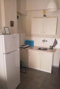 a kitchen with a white refrigerator and a sink at ELENAs in Kallithea Halkidikis