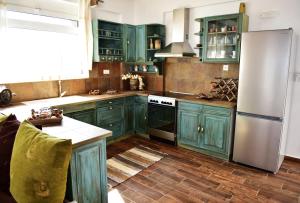 a kitchen with green cabinets and a refrigerator at Casa di Mare Stegna in Archangelos