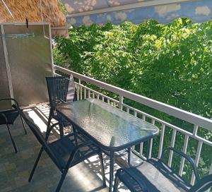 a patio table and chairs on a balcony at ELENAs in Kallithea Halkidikis