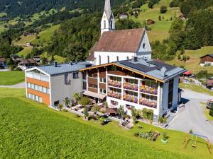 an aerial view of a building with a church at Hotel Silbertal in Silbertal