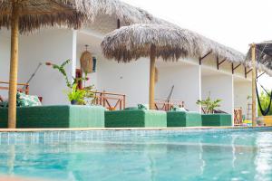 a resort with a swimming pool in front of a house at Pura Vida Hotel in Itarema