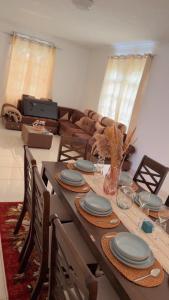 a dining room table with blue plates and a couch at Casa Lotus in Pereybere