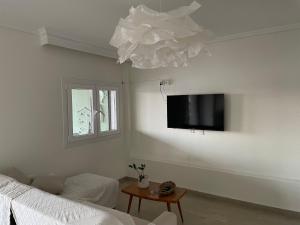 a living room with a couch and a tv on the wall at Epanomi SunSet Loft in Epanomi